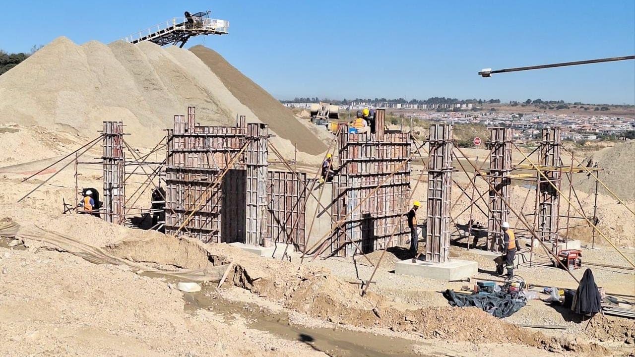 Column formwork erected alongside bulk earthworks and a stockpile