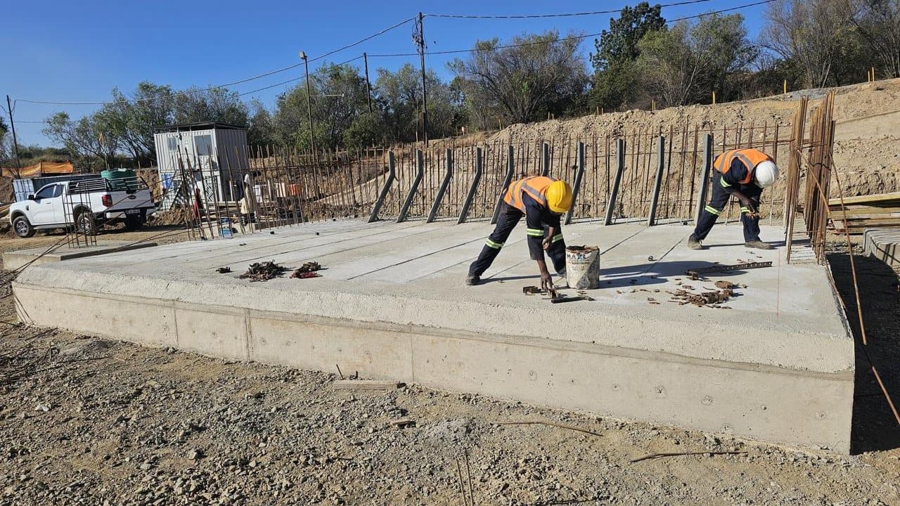 Two workers finishing a large concrete apron